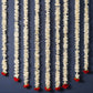 Decorative string with white floral strands and red flower buds on a dark blue background