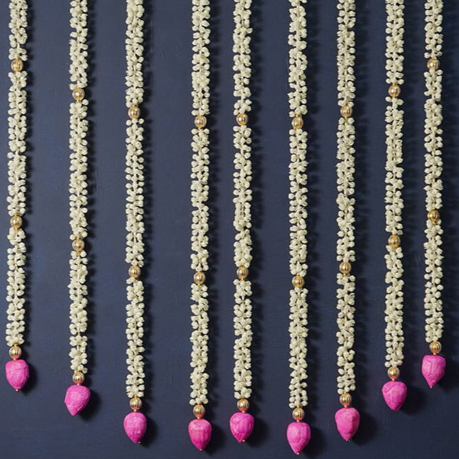Decorative garlands with pink heart-shaped beads on a dark background